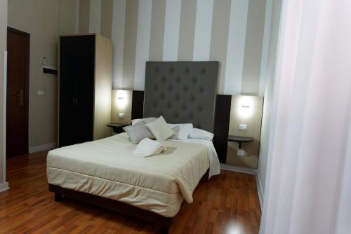 a bedroom with a large bed and two lamps at Hotel Sant'Elia in Messina