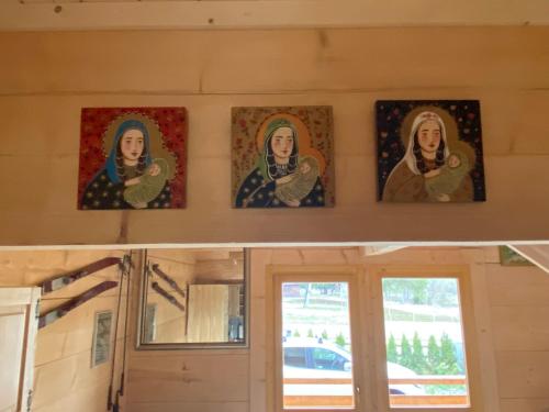 four paintings of nuns on the wall of a house at Domek góralski Cudna izba in Witów