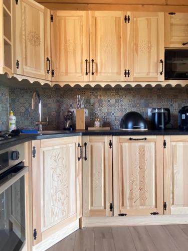 a kitchen with wooden cabinets and a counter top at Domek góralski Cudna izba in Witów