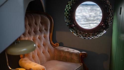 a mirror and a chair in a room at Amsterdam Center - Houseboat B&B by Captain Ricard in Amsterdam