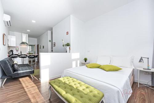 um quarto branco com uma cama e uma cozinha em Pérola da Terra - Estúdio no centro de Setúbal em Setúbal