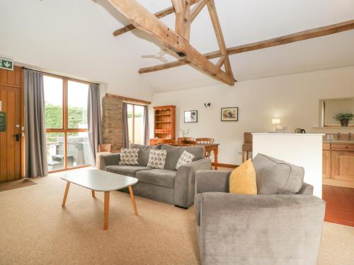 a living room with two couches and a table at Peartree Cottage in Worcester