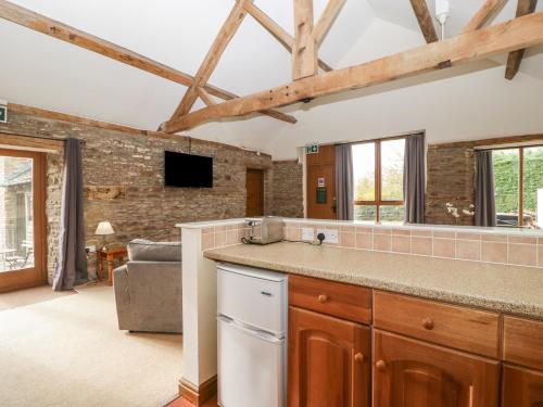 a kitchen with a counter and a living room at Peartree Cottage in Worcester