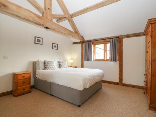 a bedroom with a large bed and a window at Peartree Cottage in Worcester