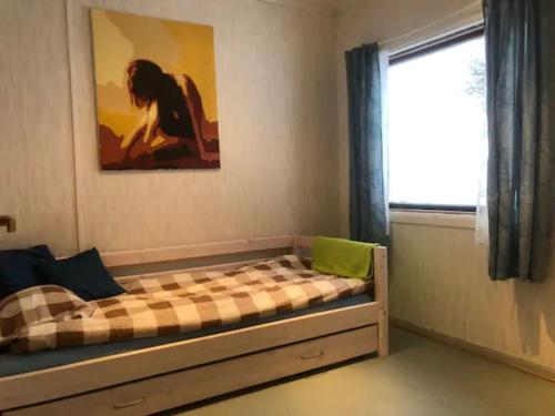 łóżko w pokoju z oknem i oknem w obiekcie Charming house in fjord Lofoten 