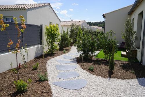 ogród z kamieniami i drzewami oraz ogrodzeniem w obiekcie Maison chaleureuse en Provence w mieście Piolenc