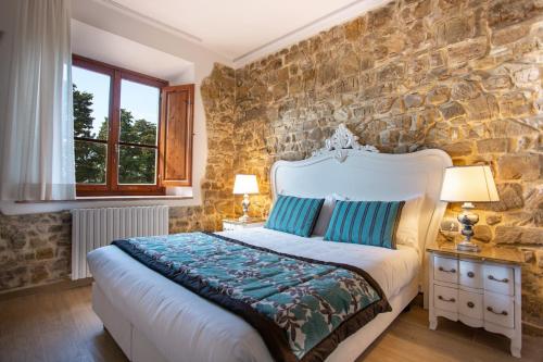 a bedroom with a large bed and a stone wall at Residenza le Colline del Paradiso in Bivigliano
