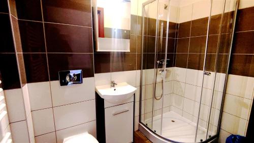 a bathroom with a shower and a toilet and a sink at Pokoje Gościnne Rozbark in Bytom