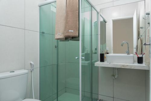 a bathroom with a glass shower and a sink at Hotel Pousada Aloha in Maceió