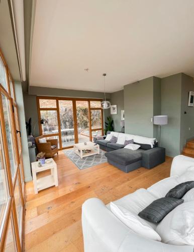 una sala de estar con 2 sofás blancos y una mesa. en Barleycove Villa, Goleen, West Cork, en Goleen