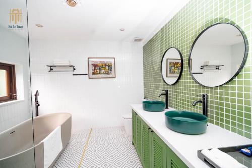 uma casa de banho com 2 lavatórios e um espelho em Hoi An Town Home Resort em Hoi An
