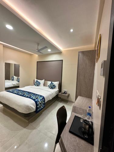 Hotel Pinaka Inn في لاكناو: غرفة فندقية بسريرين وطاولة ومكتب