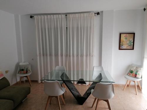 un soggiorno con tavolo e sedie in vetro di Alojamiento las Dunas a Tabernas