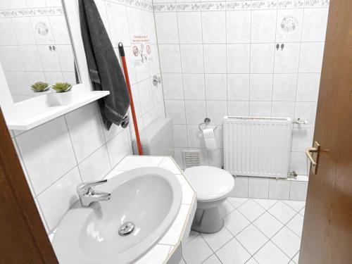 Baño blanco con lavabo y aseo en # VAZ Apartments WU11 für Monteure Küche, TV, WLAN, Parkplatz, Autobahnähe en Schwelm