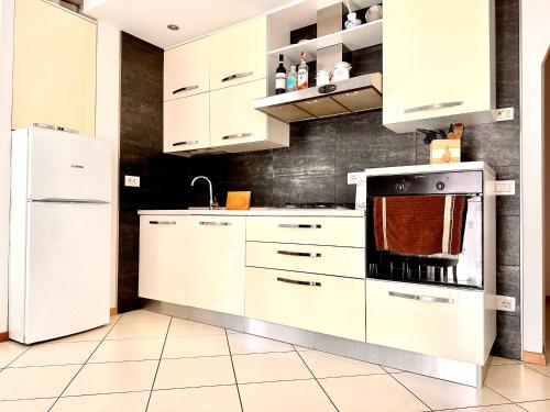 eine Küche mit weißen Schränken und einem Kühlschrank in der Unterkunft Casa Dana in Cavedine