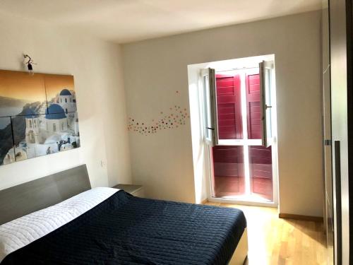 Schlafzimmer mit einem Bett und einem Fenster mit roten Rollläden in der Unterkunft Casa Dana in Cavedine