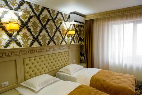 a hotel room with two beds and a wall at Little Orient in Brăila
