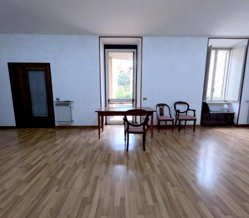ローマにあるRoma Room Hotelのテーブルと椅子2脚が備わる空き部屋
