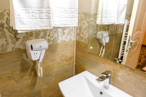 ein Bad mit einem Waschbecken und einem Spiegel in der Unterkunft Little Orient in Brăila