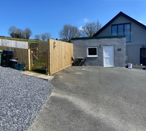 a backyard with a fence and a house at Adorable bedsit for you, partner and your pet! in Pembrokeshire