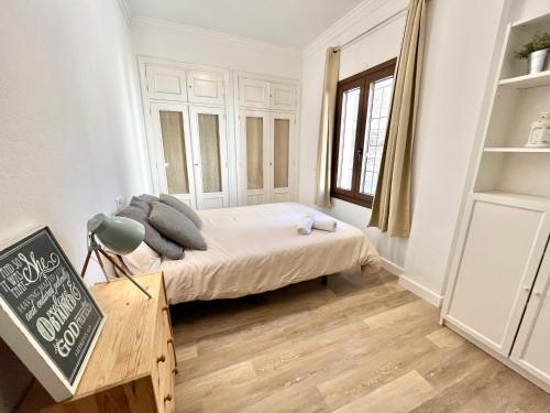 a small bedroom with a bed and a table at Apartamento centro historico in Ronda