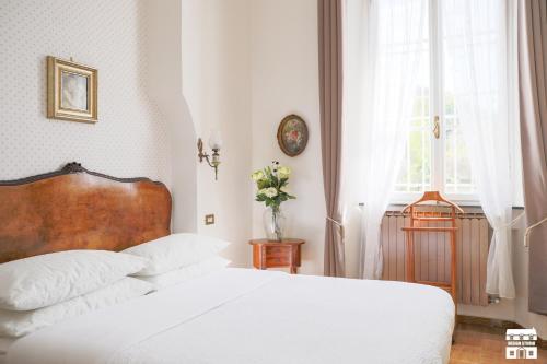 una camera con un letto bianco e una finestra di Villa Plinio Lago di Como a Dervio