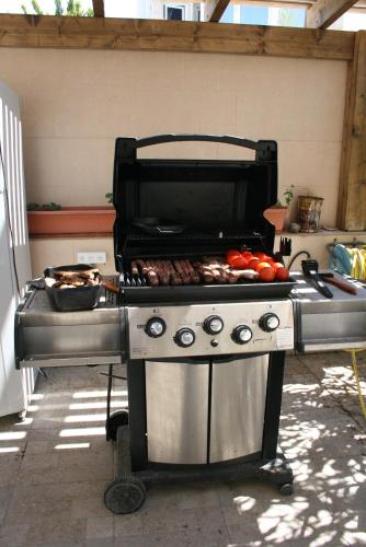 a grill with tomatoes and other food on it at Guest house Ashdod-beach in Ashdod