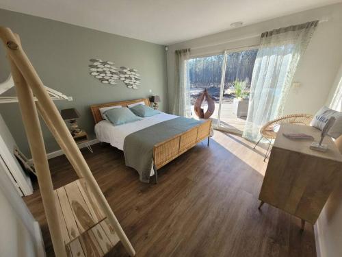 une chambre avec un lit et une porte coulissante en verre dans l'établissement Villa au cœur de la forêt, à Avensan