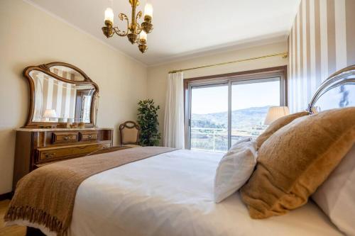 una camera da letto con un grande letto con una grande finestra di Casa da Tia Douro a Peso da Régua