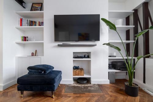 a living room with a chair and a tv on a wall at Central London apartment in Vauxhall near big Ben in London