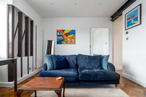 a blue couch in a living room with a table at Central London apartment in Vauxhall near big Ben in London