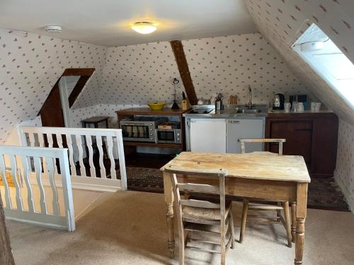 cocina con mesa y sillas en una habitación en Little Park Farm Queen Anne Farmhouse & Apartments, en Stratfield Mortimer