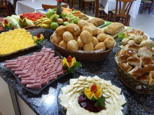 ein Tisch mit vielen verschiedenen Arten von Lebensmitteln in der Unterkunft Refúgio Costeiro II in Bombinhas