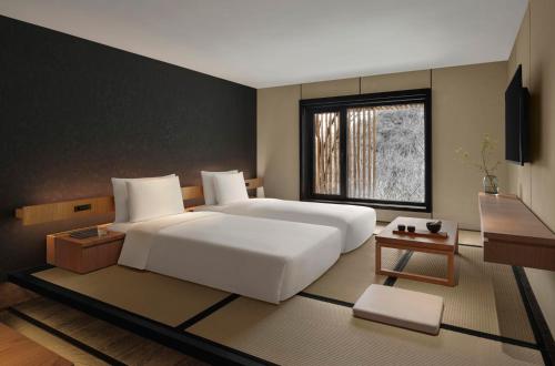a bedroom with a large white bed and a window at Commune by the Great Wall, in the Unbound Collection by Hyatt in Yanqing