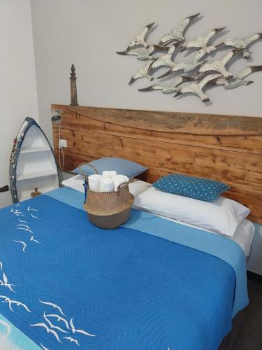 a bedroom with a blue bed with a wooden headboard at VILLA VILLACOLLE in Procchio