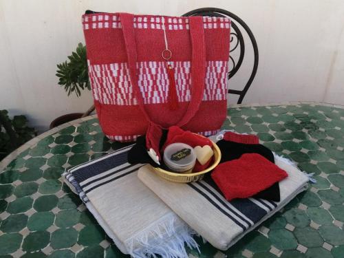 a table with a red blanket and a bowl of food at Riad Siham in El Jadida