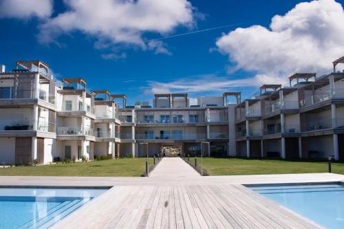 an apartment building with a pool in front of it at Caminho Real S - By SCH in Nazaré