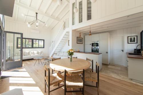 une cuisine et un salon avec une table et des chaises dans l'établissement Villa Hortense, à Lège-Cap-Ferret
