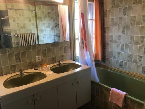 a bathroom with two sinks and a mirror and a tub at Cosy Traditional Swiss Chalet in Wengen