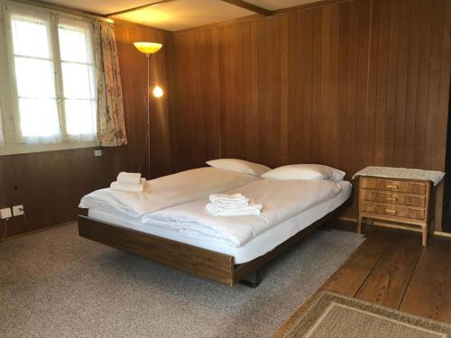 a bedroom with a bed and a table and a window at Cosy Traditional Swiss Chalet in Wengen