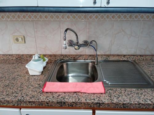 a kitchen sink with a red towel next to it at Arenas del mar in La Mareta