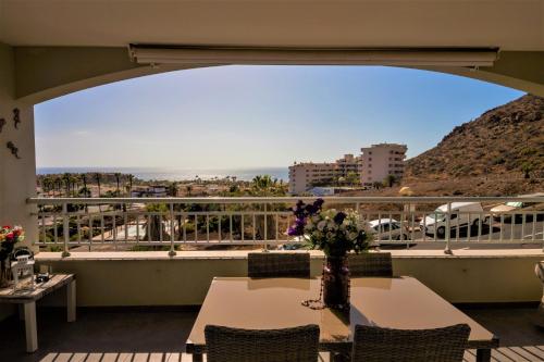 een tafel en stoelen op een balkon met uitzicht bij Comfortable apartment with amazing sea views in Palm-mar