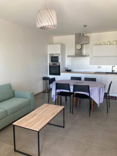 eine Küche und ein Wohnzimmer mit einem Tisch und einem Sofa in der Unterkunft Ferme Hôtel Boulage in Marquefave