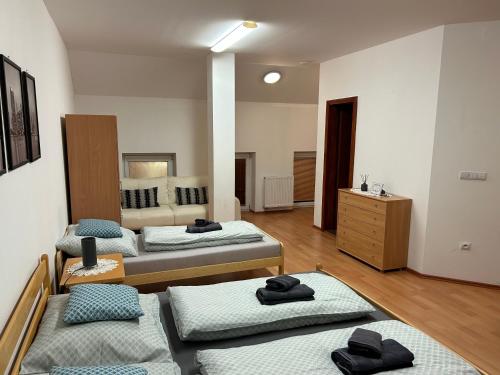 a room with three beds and a dresser at Kondé Apartments D in Dunajská Streda