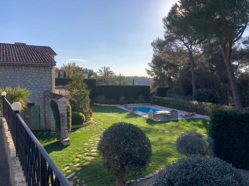 une cour avec une piscine et une clôture dans l'établissement Discover a luxurious villa with a stunning pool and a lush garden , the ultimate escape for rest and relaxation, à Saint-Paul-de-Vence
