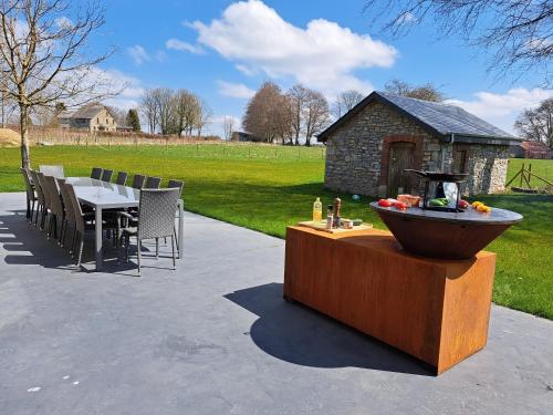 una mesa con sillas y una fuente en un patio en Les Highlands - Maison de vacances, en Houffalize