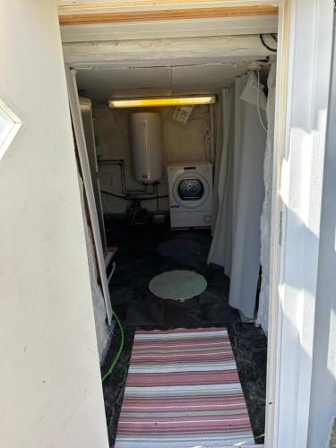 a small bathroom with a washing machine in a room at Söt liten stuga för 2 in Strömstad