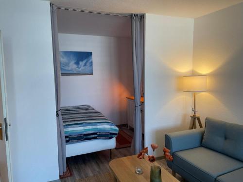 un soggiorno con divano blu e specchio di Ferienwohnung "'Strandgut" a Heiligenhafen