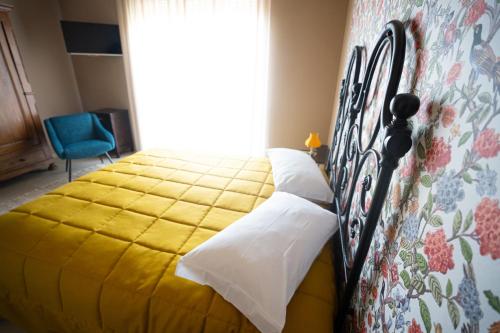 a bedroom with a bed with a yellow bedspread at CA'du LIN - Jacuzzi e Piscina in Cisterna dʼAsti