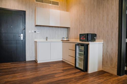 una cocina con armarios blancos y una puerta negra en M14 Hotel Apartment, en Ras al Khaimah